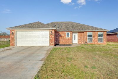 Single story home with a front lawn and a garage | Image 1