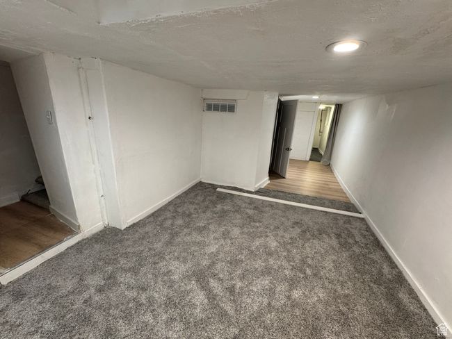 Finished below grade area with carpet flooring, a textured ceiling, and baseboards | Image 16