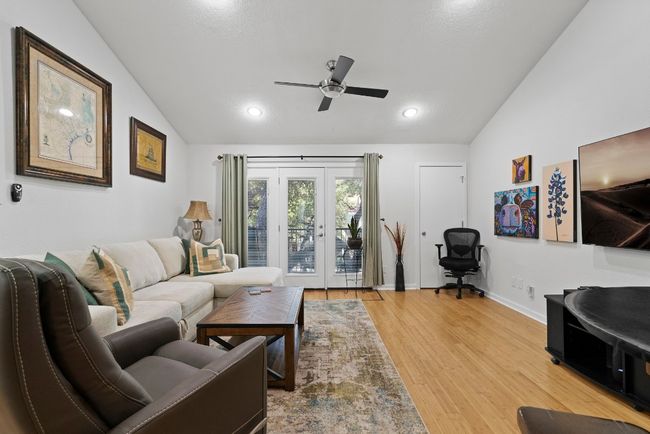 Living room featuring lofted ceiling, a ceiling fan, light wood finished floors, french doors, and baseboards | Image 8