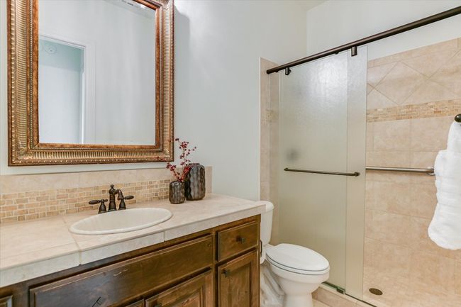 Full bathroom downstairs, guest bathroom or in law floorplan, walk-in shower with bar, travertine flooring | Image 26