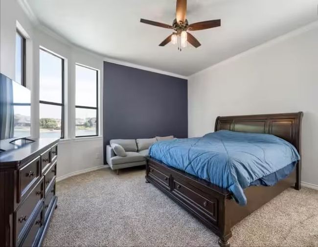 Bedroom featuring light colored carpet, crown molding, and ceiling fan | Image 12