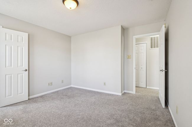 unfurnished bedroom featuring carpet, a textured ceiling, and baseboards | Image 58