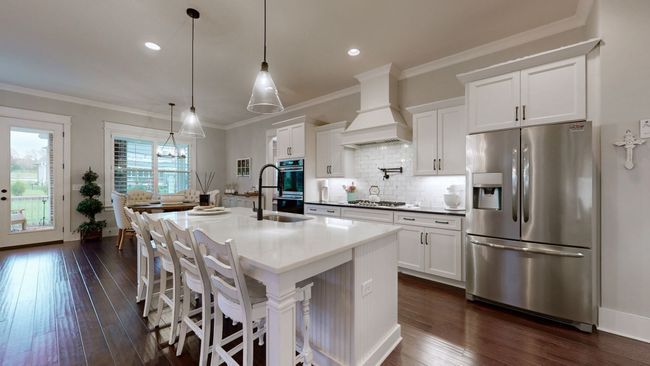 Dream kitchen featuring exquisite cabinetry, large center island w/quartz countertop & top tier appliances-perfect for cooking and entertaining | Image 18