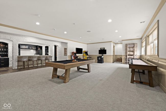 rec room featuring pool table, wet bar, crown molding, wainscoting, and carpet | Image 73