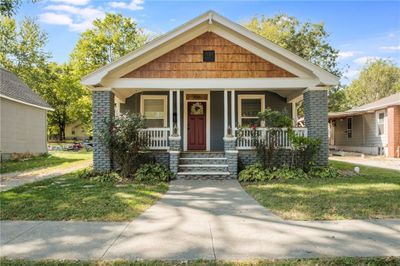 Bungalow-style house with a front lawn and covered porch | Image 1