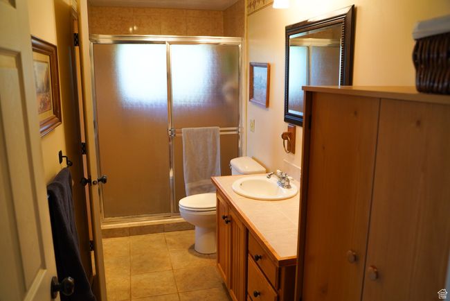 Full bathroom featuring a stall shower, vanity, and tile patterned flooring | Image 22