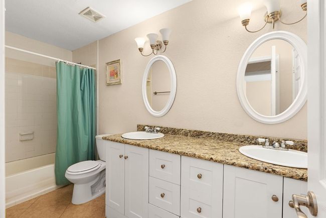 Bathroom with tile patterned floors, visible vents, a sink, and toilet | Image 22