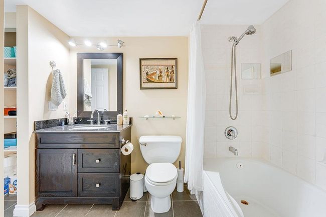 Full bath featuring vanity, tile patterned floors, toilet, and shower / bath combo with shower curtain | Image 18