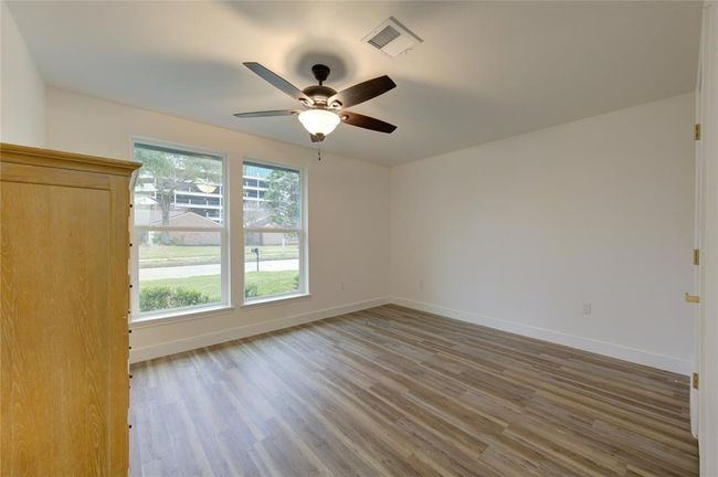 The home features two spacious secondary bedrooms, each designed with comfort and style in mind. Both rooms boast luxury vinyl flooring, providing a sleek and durable surface that is easy to maintain. Large new windows allow for plenty of natural light, creating a bright and inviting atmosphere. | Image 24