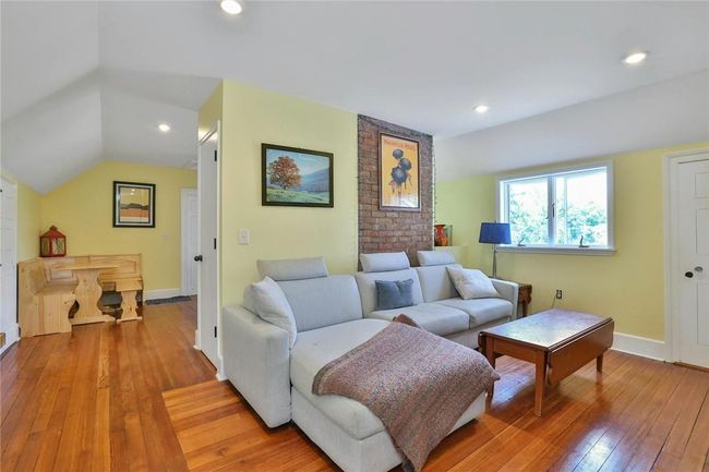 Third floor living/ dining, lofted ceiling, accented by a brick wall and hardwood floors | Image 29