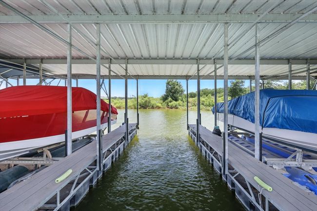 Dock featuring boat lift and a water view | Image 36