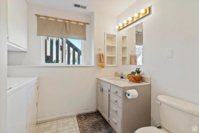 3/4 bath featuring washing machine and dryer, vanity, toilet, and tile patterned floors | Image 18