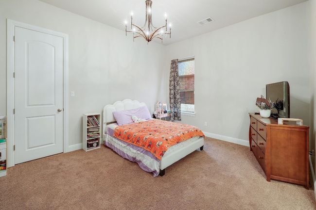 Bedroom featuring light colored carpet and a chandelier | Image 25
