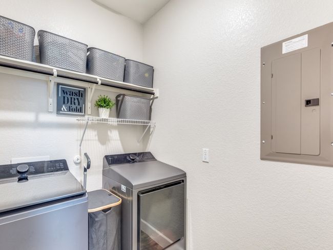 Laundry area with electric panel, separate washer and dryer, and a textured wall | Image 15