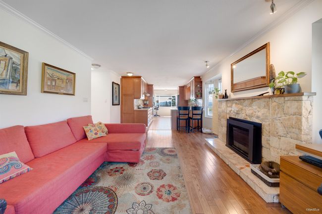 Living room with crown molding, light wood-style flooring, and a fireplace | Image 18