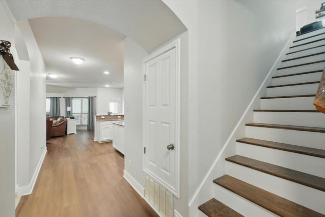 Stairs featuring arched walkways, wood finished floors, and recessed lighting | Image 12