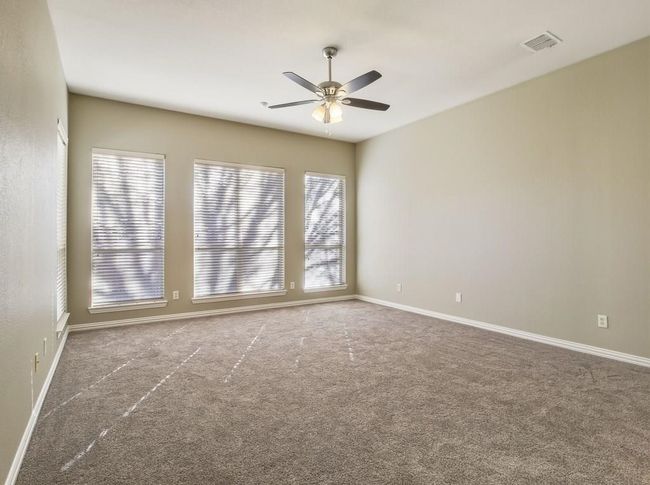 Carpeted spare room featuring a ceiling fan and baseboards | Image 11