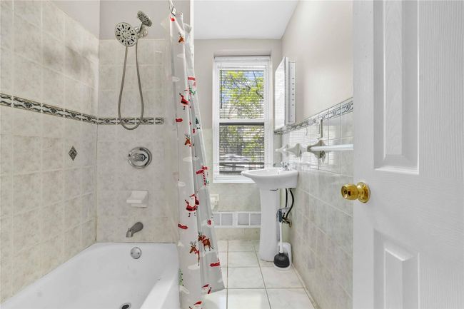 Full bath featuring shower / bath combination with curtain, tile patterned flooring, and tile walls | Image 11
