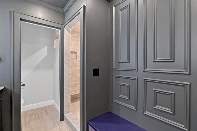 Features private commode space, paneled accent wall and bench. Walk in shower with oversized subway tile, floating bench and brass fixtures. | Image 26