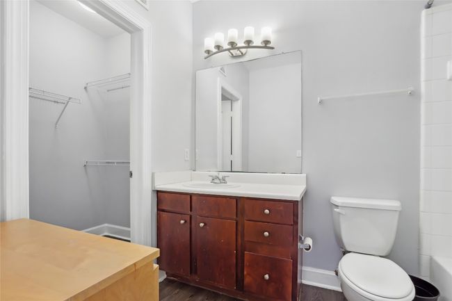 Full bath featuring baseboards, toilet, wood finished floors, vanity, and a shower | Image 23
