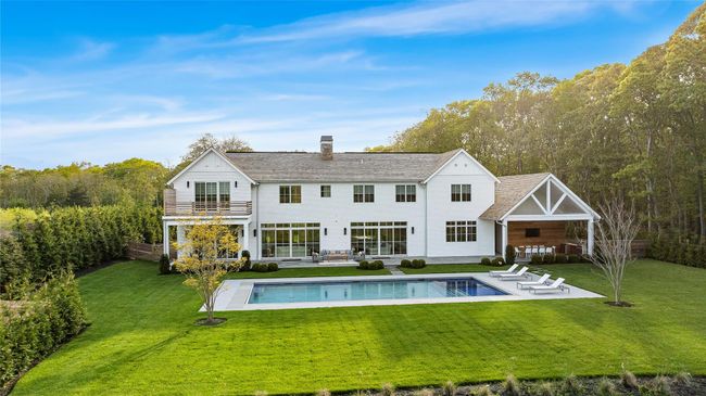 Back of property featuring a balcony, a yard, a patio, a chimney, and an outdoor pool | Image 41