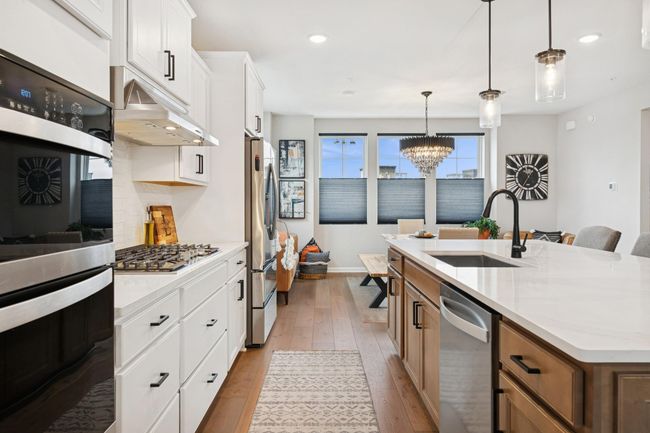 Spacious kitchen layout with ample room between the counter, stove, and fridge, featuring an island with a single sink for added convenience. | Image 20