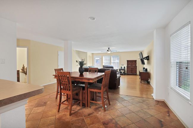 Dining area featuring ceiling fan and stone tile floors | Image 7