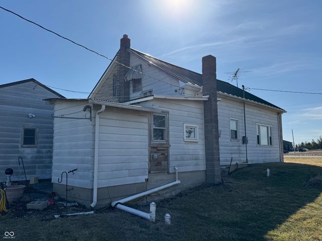 view of side of property featuring a lawn, a chimney, and metal roof | Image 8