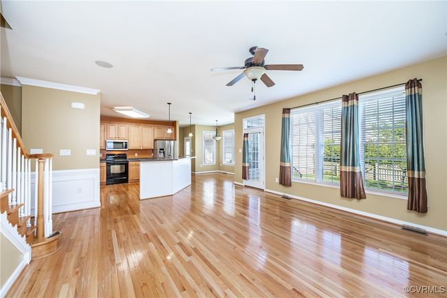 Unfurnished living room with stairs, light wood-style floors, and a ceiling fan | Image 15