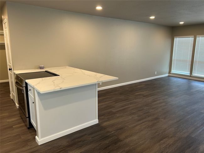 Kitchen with stainless steel electric range, baseboards, dark wood-style flooring, white cabinetry, and recessed lighting | Image 15