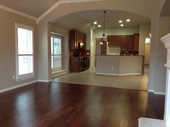 Kitchen featuring electric range oven, crown molding, arched walkways, and light wood finished floors | Image 4
