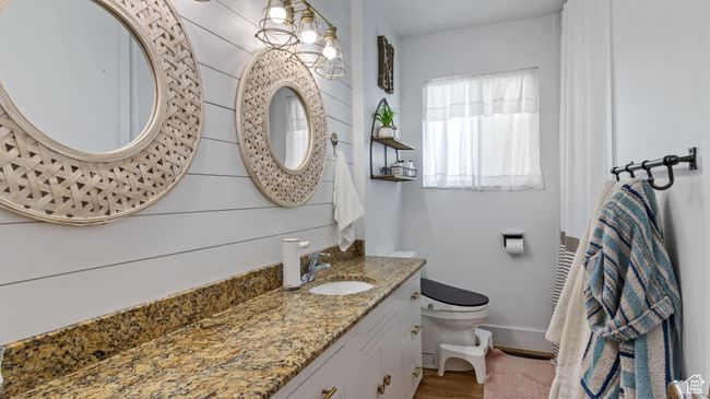 Bathroom featuring toilet, vanity, wood finished floors, and baseboards | Image 13