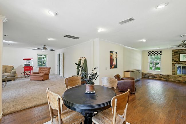 Dining room with ceiling fan, wood finished floors, recessed lighting, a fireplace, and crown molding | Image 16