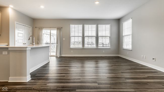 unfurnished living room featuring a wealth of natural light, baseboards, and dark wood finished floors | Image 9