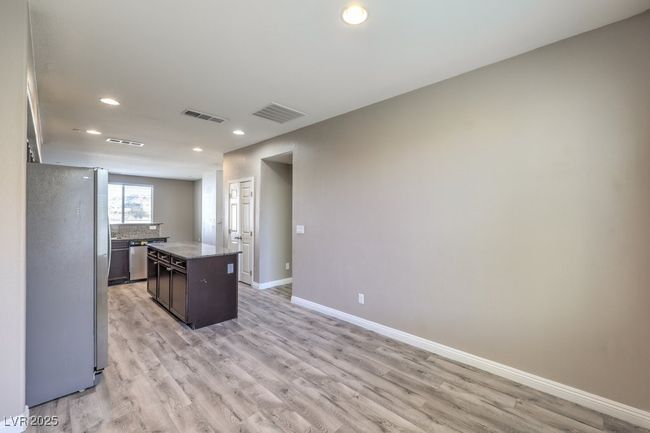 Kitchen with light wood-style flooring, visible vents, a kitchen island, and freestanding refrigerator | Image 33