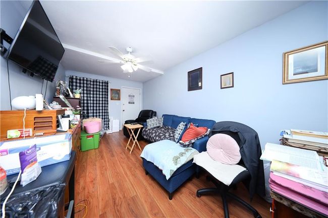 Living area with wood finished floors and a ceiling fan | Image 10