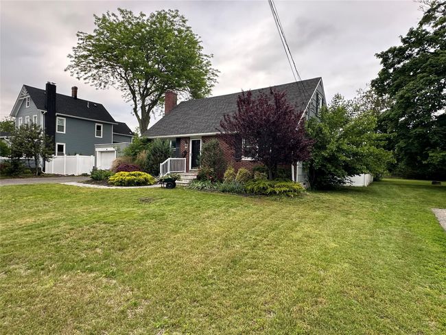 View of front of property with a garage, asphalt driveway, brick siding, and a chimney | Image 4