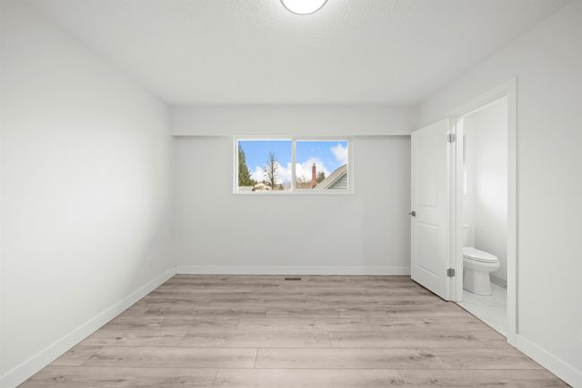 Unfurnished bedroom with baseboards, connected bathroom, and light wood-style flooring | Image 14