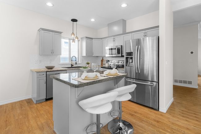 Kitchen featuring appliances with stainless steel finishes, gray cabinets, a sink, light wood-style flooring, and recessed lighting | Image 14