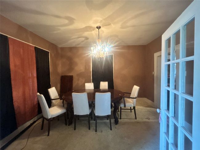 Carpeted dining space with a chandelier | Image 9