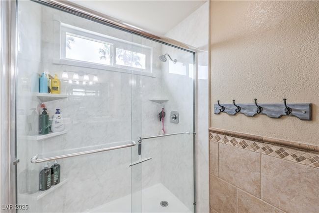 Full bathroom with tile walls, a shower stall, and a textured wall | Image 30