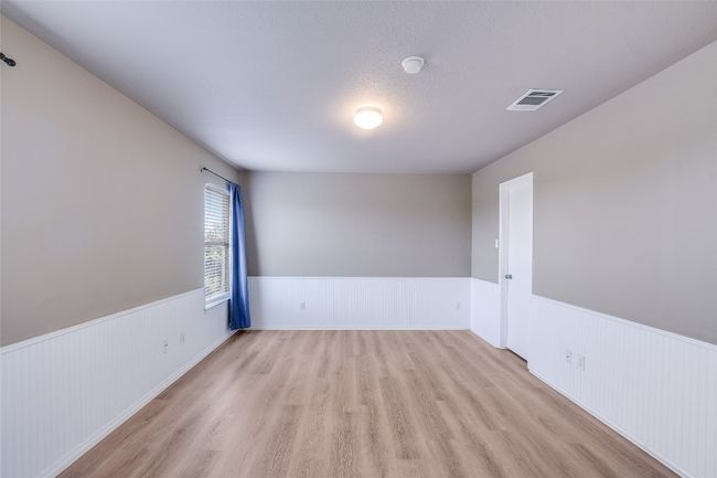 Spare room featuring a wainscoted wall and light wood-style floors | Image 10