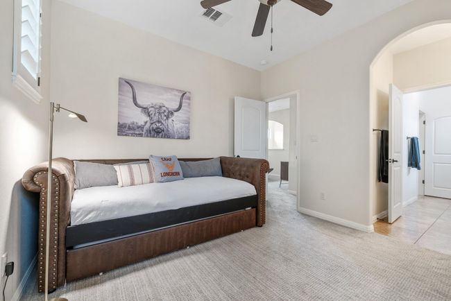 Bedroom featuring arched walkways, carpet, ceiling fan, and baseboards | Image 26