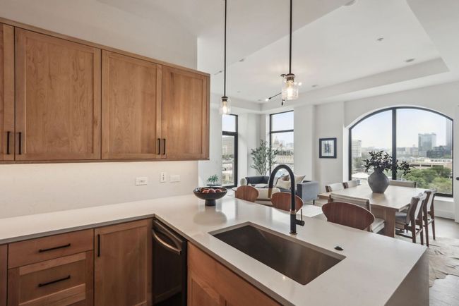 Kitchen featuring a city view, open floor plan, light countertops, stainless steel dishwasher, and a sink | Image 9