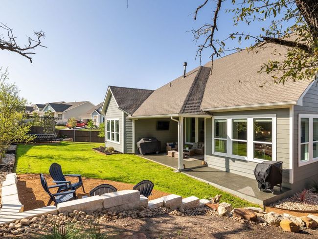 Rear view of house featuring a shingled roof, a patio area, fence, and a lawn | Image 17