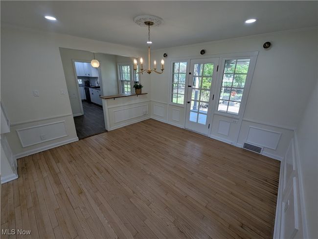 Unfurnished dining area featuring visible vents, a decorative wall, and a chandelier | Image 11