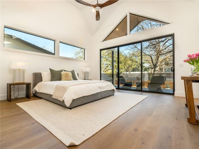 Bedroom with access to outside, high vaulted ceiling, wood finished floors, and ceiling fan | Image 9