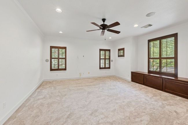 Carpeted empty room featuring crown molding, plenty of natural light, ceiling fan, and recessed lighting | Image 20