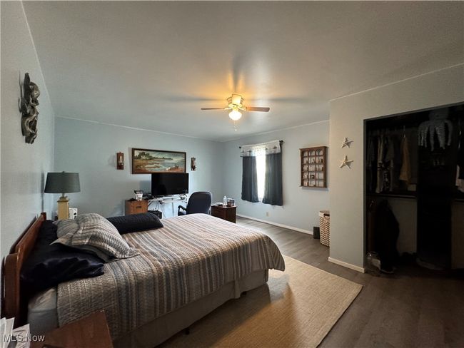 Bedroom featuring wood finished floors, a ceiling fan, a desk, baseboards, and a closet | Image 19