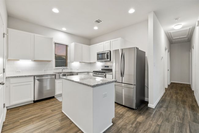 Kitchen with visible vents, white cabinets, appliances with stainless steel finishes, and a sink | Image 8